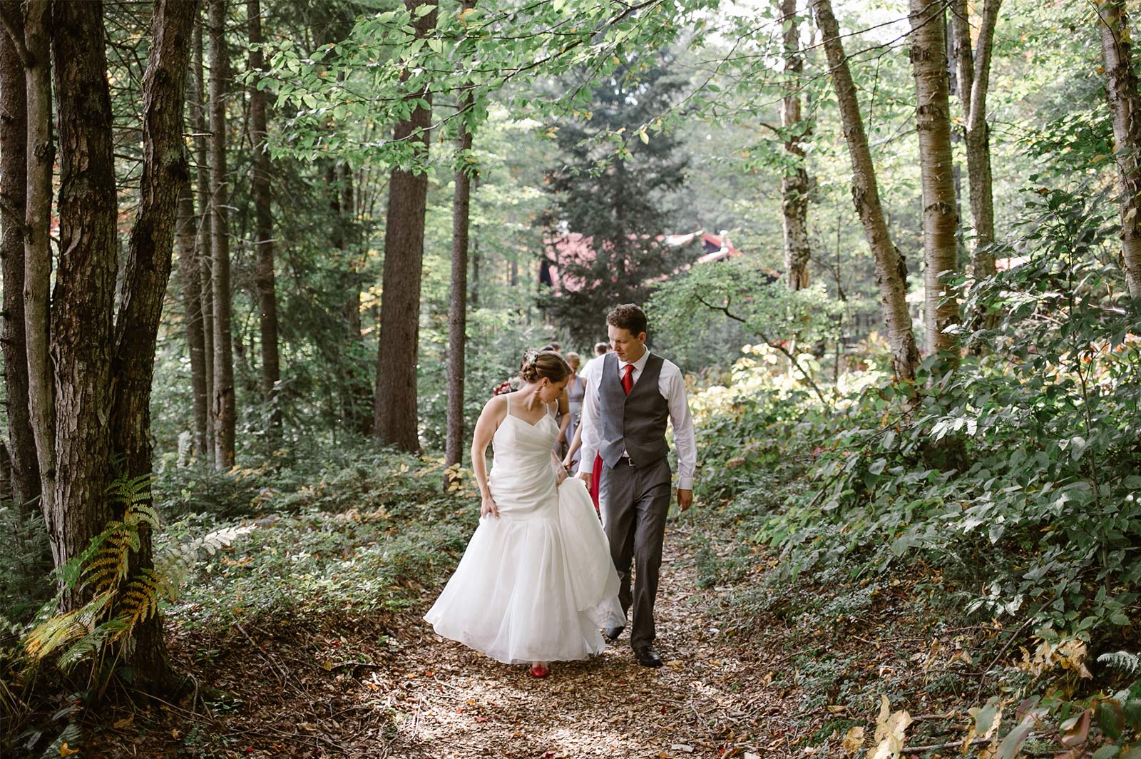 Bride and groom walking through forest