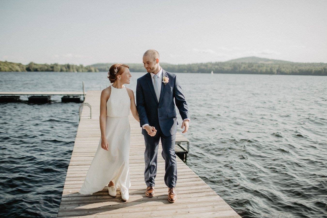 Wedding couple walking on lake dock