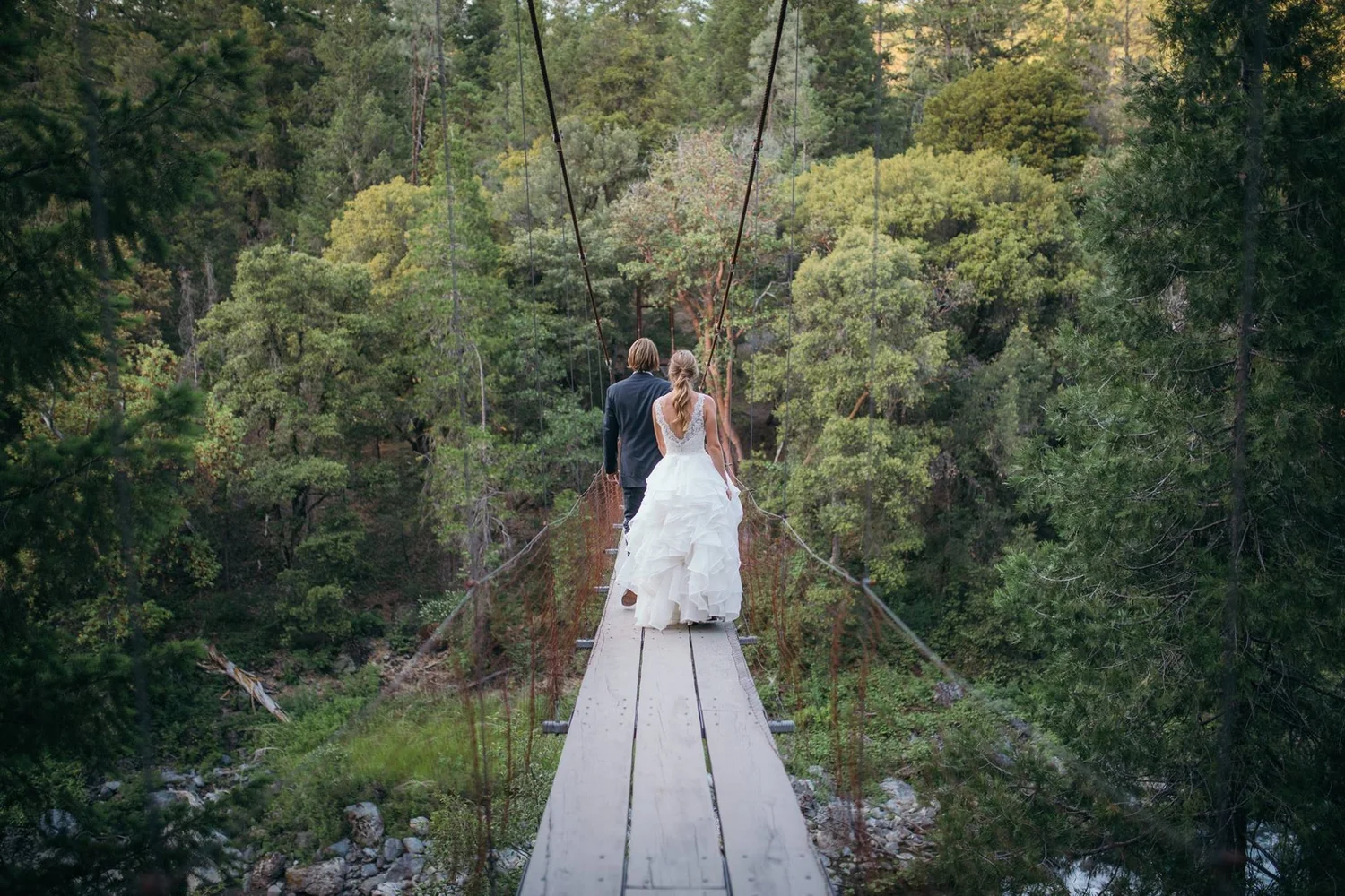 Couple walking on a suspended wooden bridge