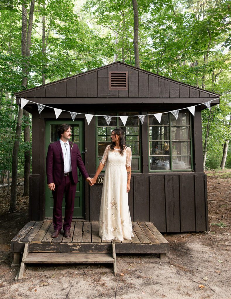 Bride and groom outside summer camp cabin