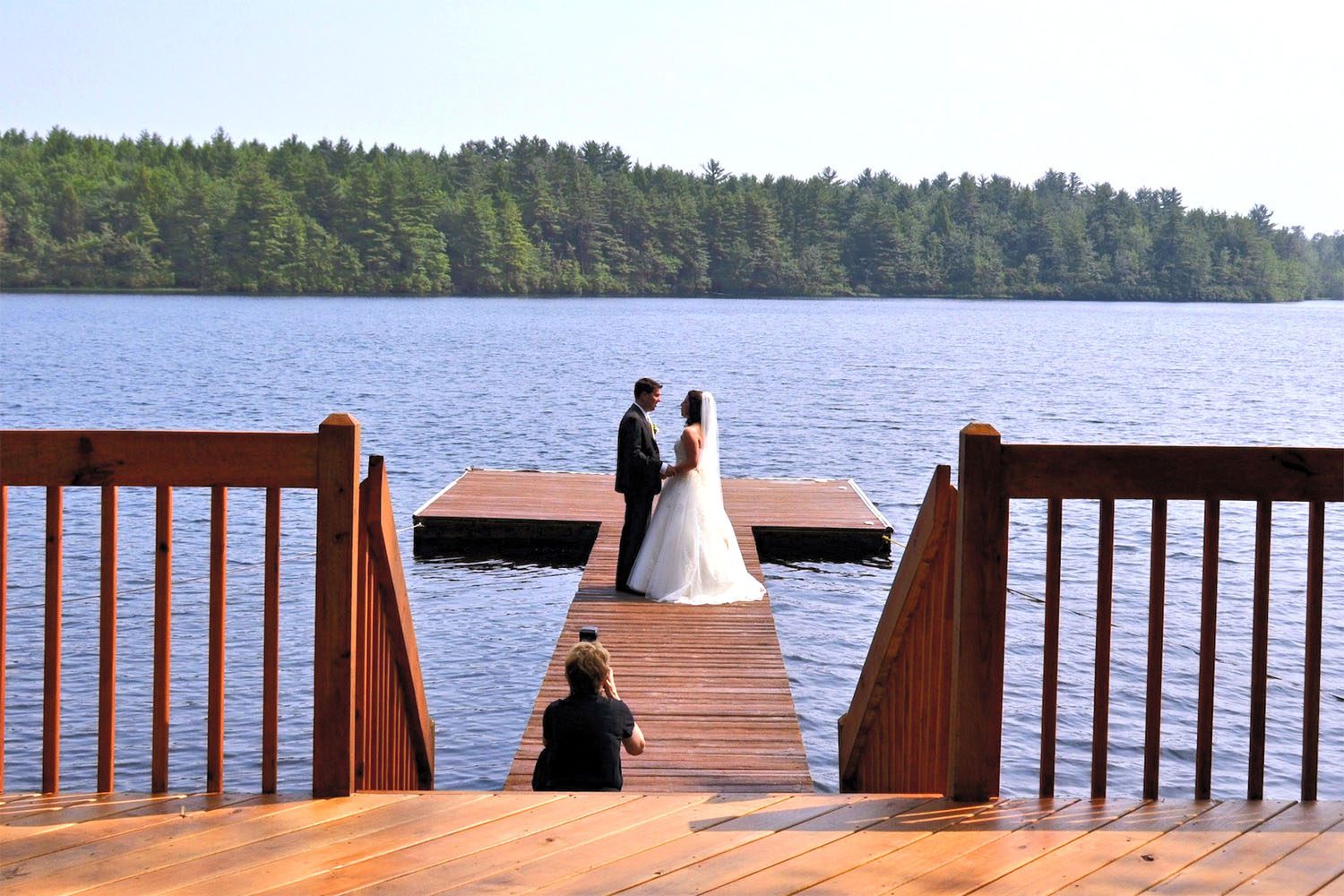 Bride and groom on lake dock