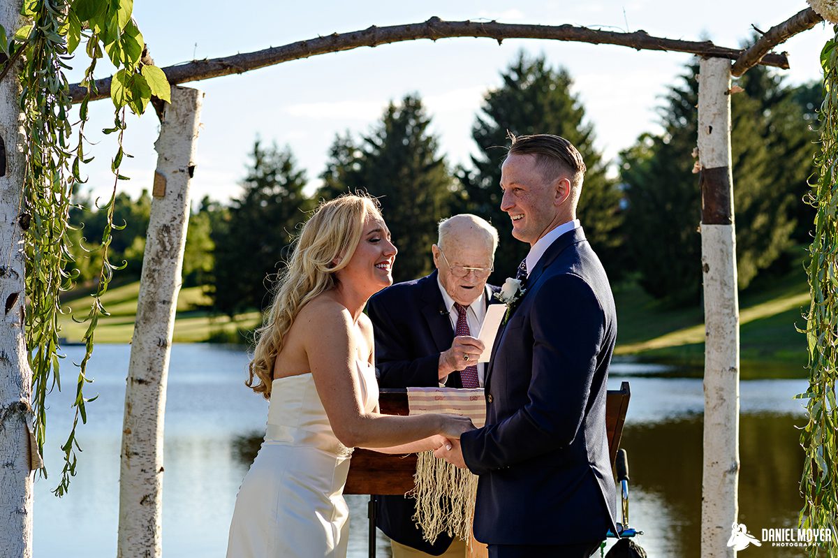 Bride and groom saying vows by lake