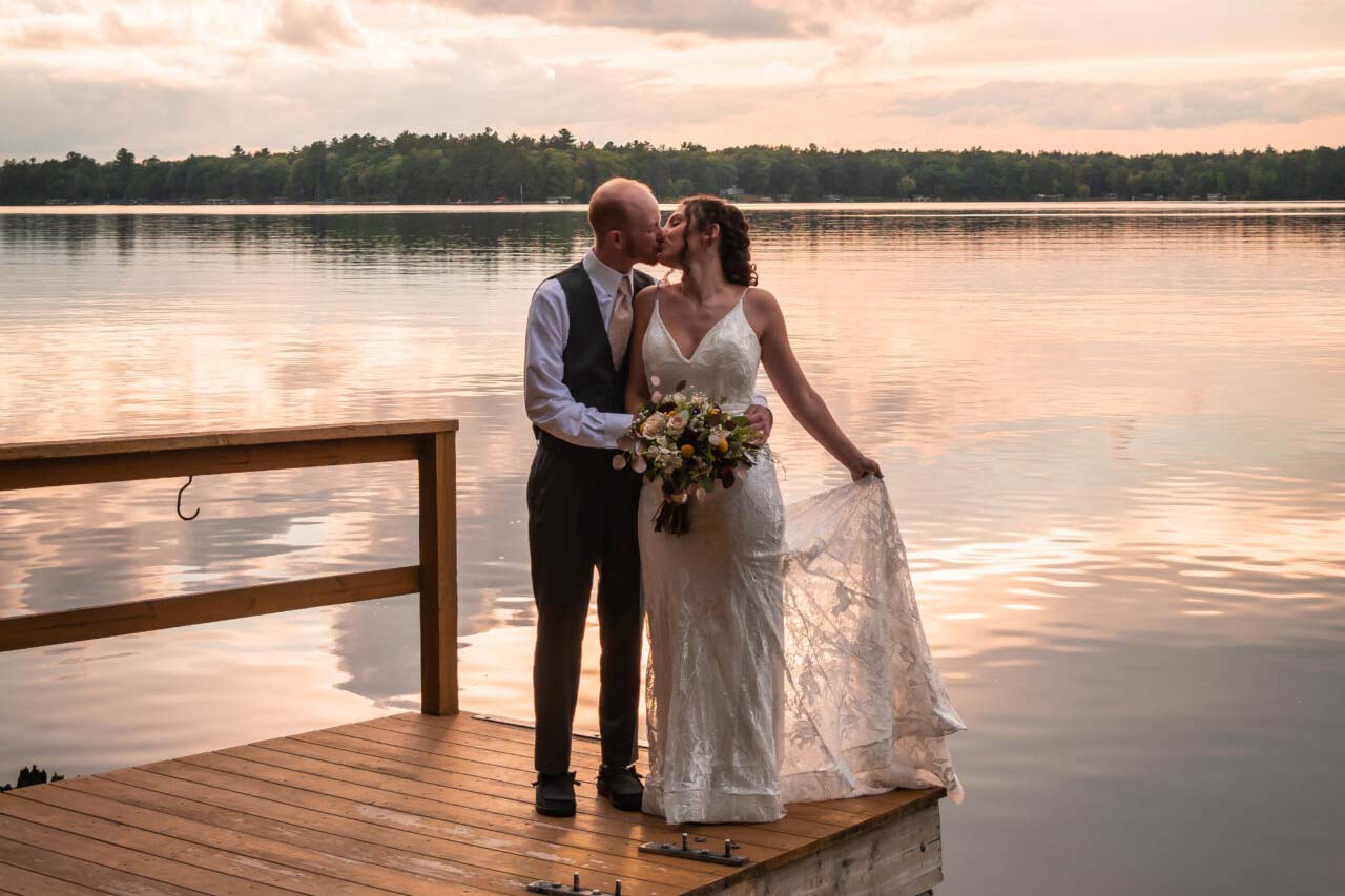 Bride and groom embracing on sunset dock