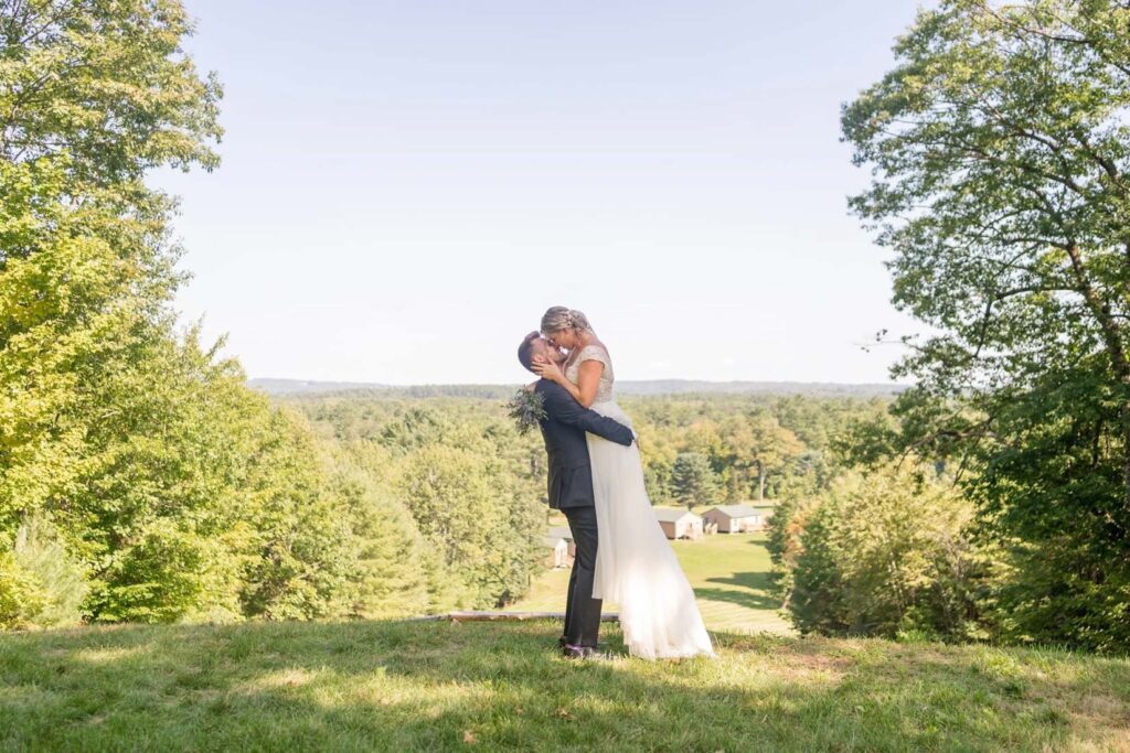 Bride and groom embracing on hill