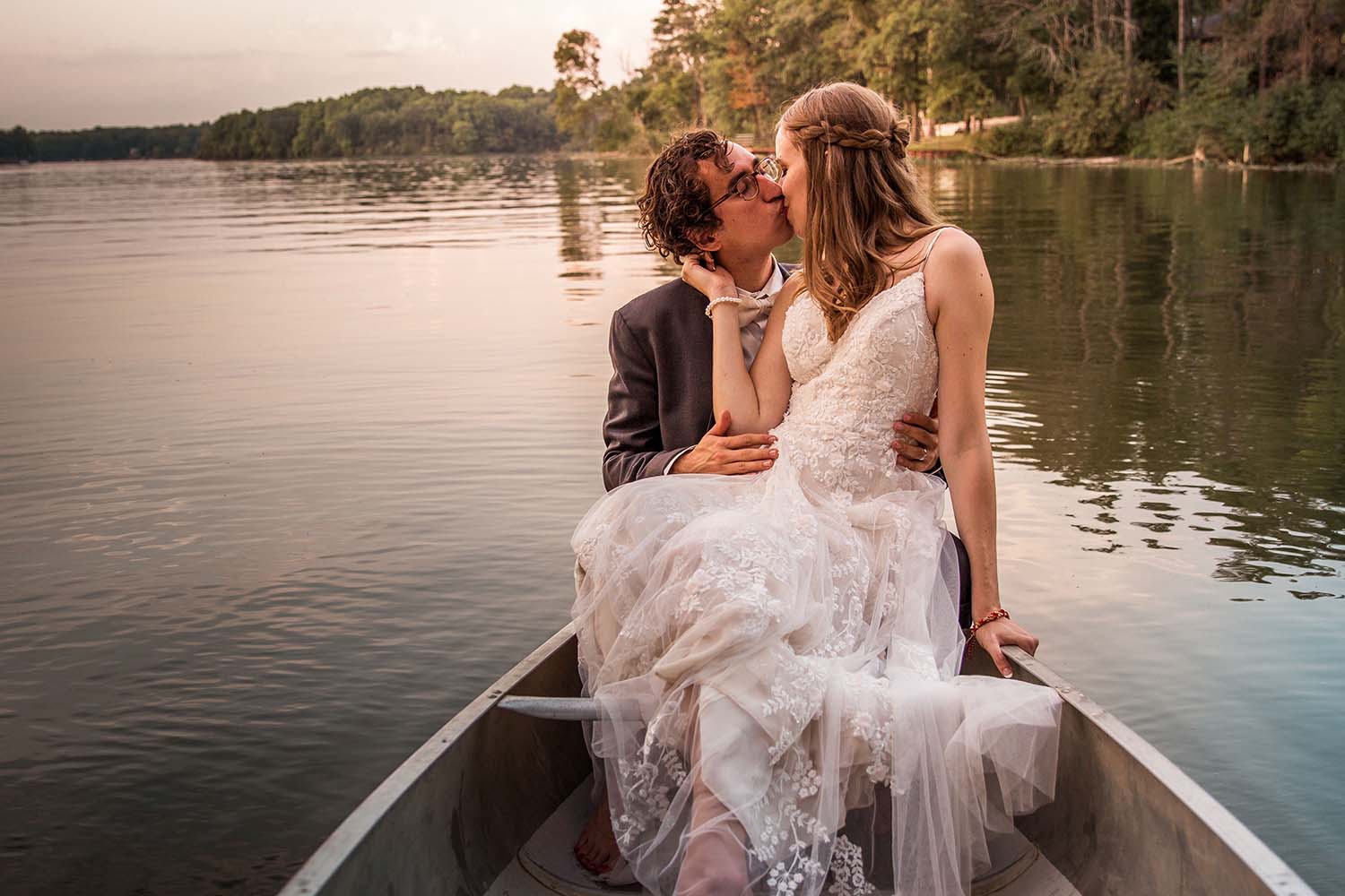 Bride and groom embracing in a canoe on the lake