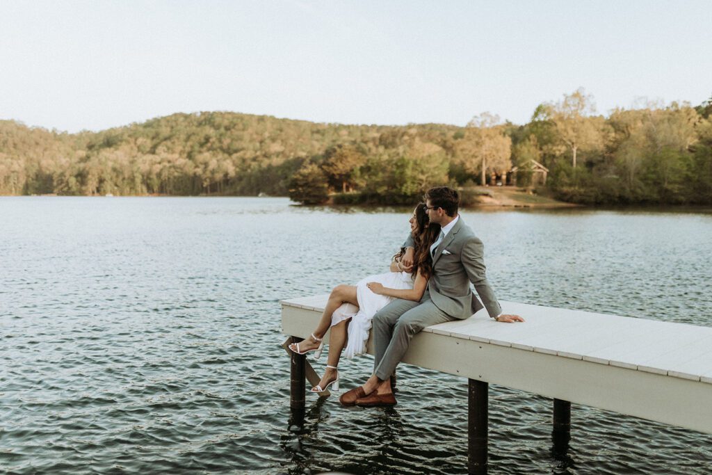 Bride and groom sitting on camp dock