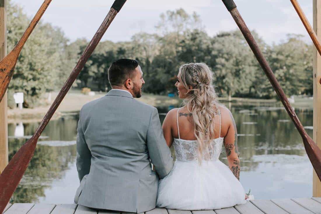 Couple sitting on dock looking at each other